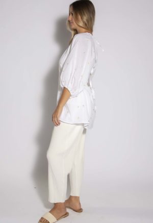 Side view of straight size model wearing White with Embroidered Flowers Keyhole Back Top.