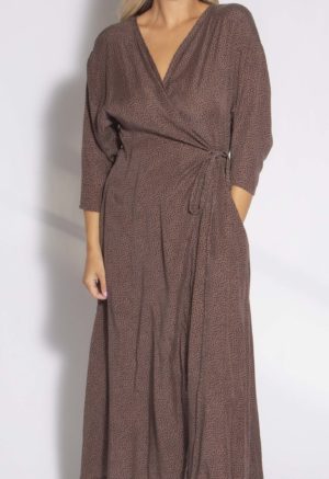 Close-up front view of straight size model wearing Brown with Black Spots Wrap Dress.
