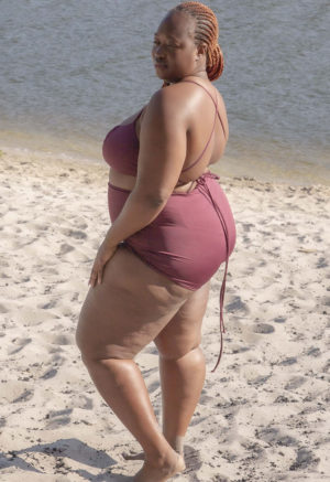 Side/back view of plus size model wearing Fig Ruched Top.