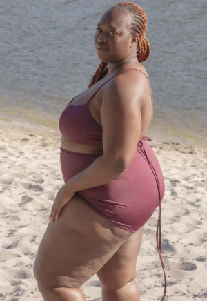 Side view of plus size model wearing Fig Ruched Top.