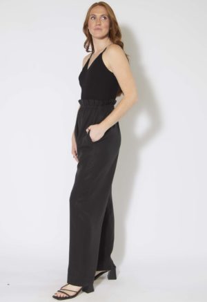Side view of straight size model wearing Black Lyocell Paper Bag Trousers.