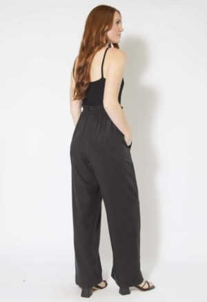 Back/side view of straight size model wearing Black Lyocell Paper Bag Trousers.