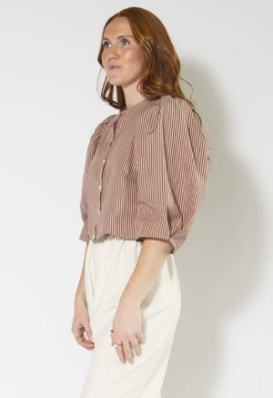 Front/side view of straight size model wearing Burgundy and Tan Stripe Puff Sleeve Cropped Top.