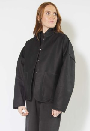 Front/side view of straight size model wearing Black Hemp Round Collar Jacket.