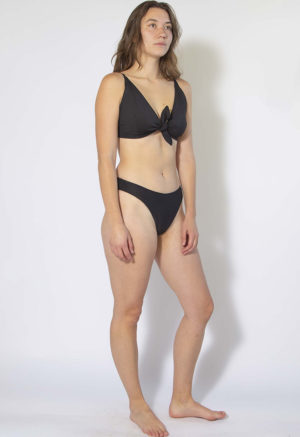 Front/side view of straight size model wearing Black High Rise Bikini Bottoms.