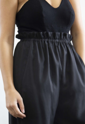 Close-up front view of straight size model wearing Black Lyocell Paper Bag Trousers.