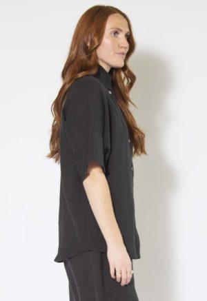 Side view of straight size model wearing Black Linen Dolman Sleeve Button-Up.