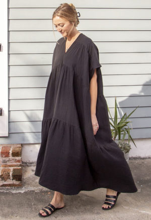 Front/side view of straight size model wearing Black Gauze Double V Tiered Maxi Dress.