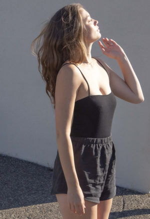 Side view of straight size model wearing Black Linen Short Shorts.