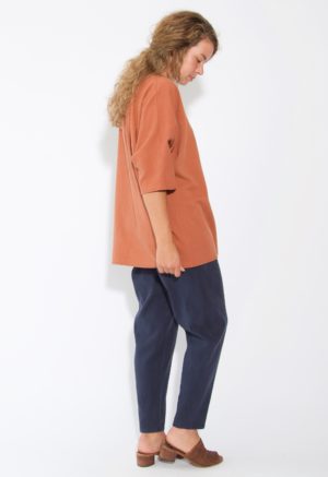 Side view of straight size model wearing Gingerbread V-Neck Top.