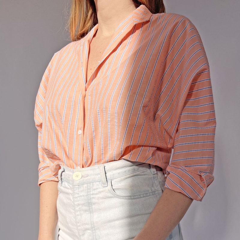 Close-up front view of straight size model wearing Peach Stripe Limited Edition Long Sleeve Dolman Button-Up Top.