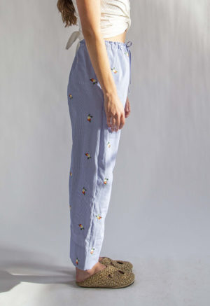 Side view of straight size model wearing Embroidered Blue Stripe Limited Run Drawstring Wide-Leg Pant.