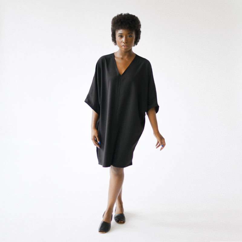 Front view of straight size model wearing Black V-Neck Dress.