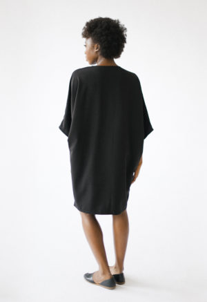 Back view of straight size model wearing Black V-Neck Dress.