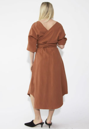 Back view of straight size model wearing Gingerbread Midi Reversible Wrap Dress.