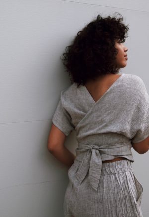 Back view of straight size model wearing Light Gray Short Sleeve Reversible Wrap Top.