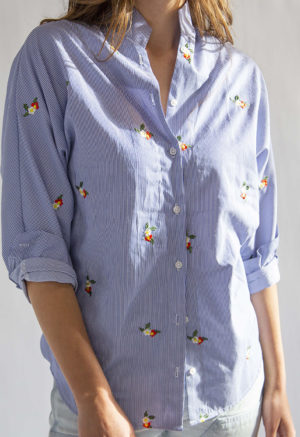 Close-up front view of straight size model wearing Embroidered Blue Stripe Limited Run Long Sleeve Dolman Button-Up Top.