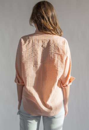 Back view of straight size model wearing Peach Stripe Limited Edition Long Sleeve Dolman Button-Up Top.