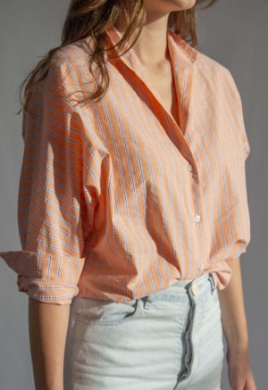 Close-up front view of straight size model wearing Peach Stripe Limited Edition Long Sleeve Dolman Button-Up Top.