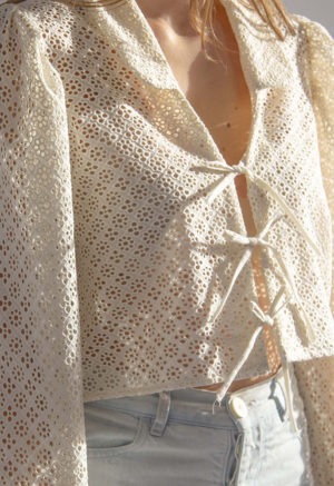 Close-up front/side view of straight size model wearing Cream Eyelet Limited Edition Beverly Top.