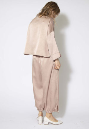 Back/side view of straight size model wearing Shiny Pale Pink Drawstring Waist/Hem Pant.