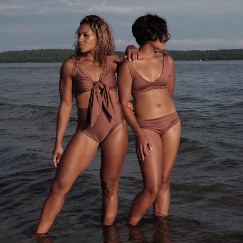 two women standing in water in chestnut bikinis