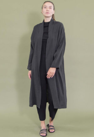 Woman in black rib pants, top and black linen oversized midi jacket