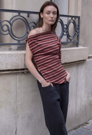 woman in red strip off the shoulder top and black pants walking on a street