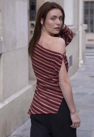 woman in red strip off the shoulder top and black pants walking on a street