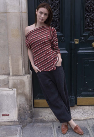 woman in red strip off the shoulder top and black pants walking on a street