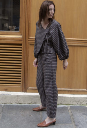 woman wearing dark grey balloon sleeve top and matching barrel leg pants