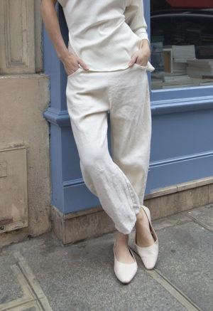 woman in cream pants, cream rib top and cream shoes standing on street