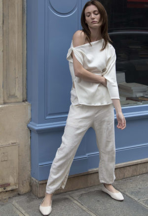 woman in cream pants, cream rib top and cream shoes standing on street