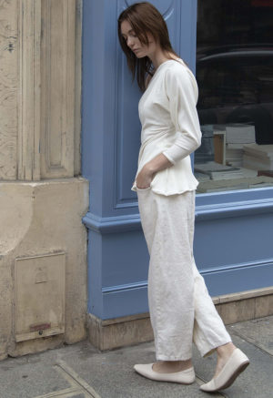 woman in cream pants, cream rib top and cream shoes standing on street