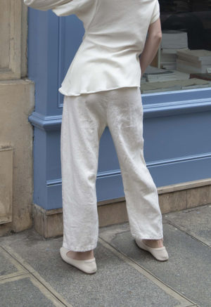 woman in cream pants, cream rib top and cream shoes standing on street