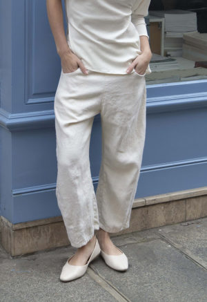 woman in cream pants, cream rib top and cream shoes standing on street