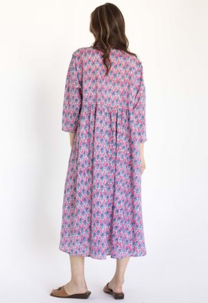women wearing pink floral oversized dress with dolman sleeves, collar and ties at neck