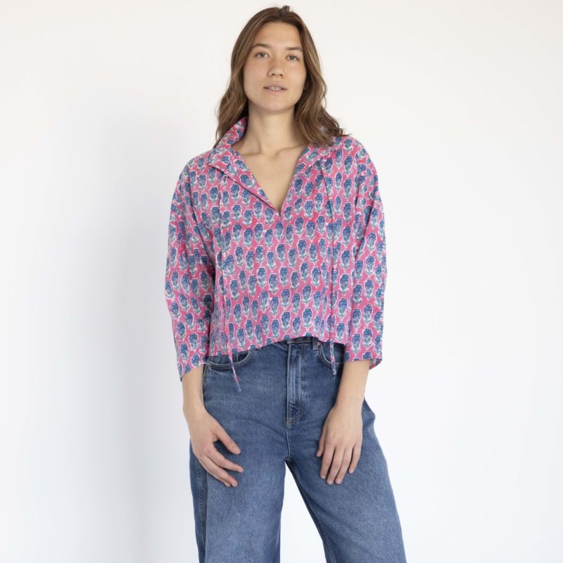 woman wearing pink floral collar tie top with dark blue jeans