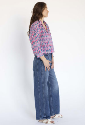 woman wearing pink floral collar tie top with dark blue jeans