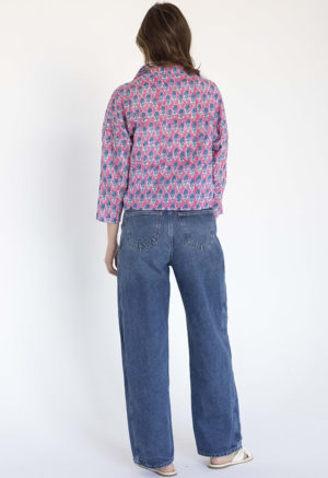 woman wearing pink floral collar tie top with dark blue jeans