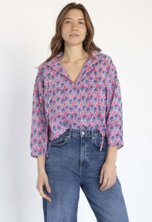 woman wearing pink floral collar tie top with dark blue jeans