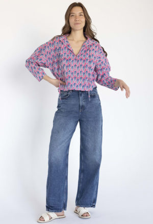 woman wearing pink floral collar tie top with dark blue jeans