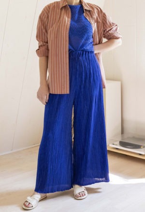 woman in royal blue pleated wide-leg pants and royal blue knit short sleeve top