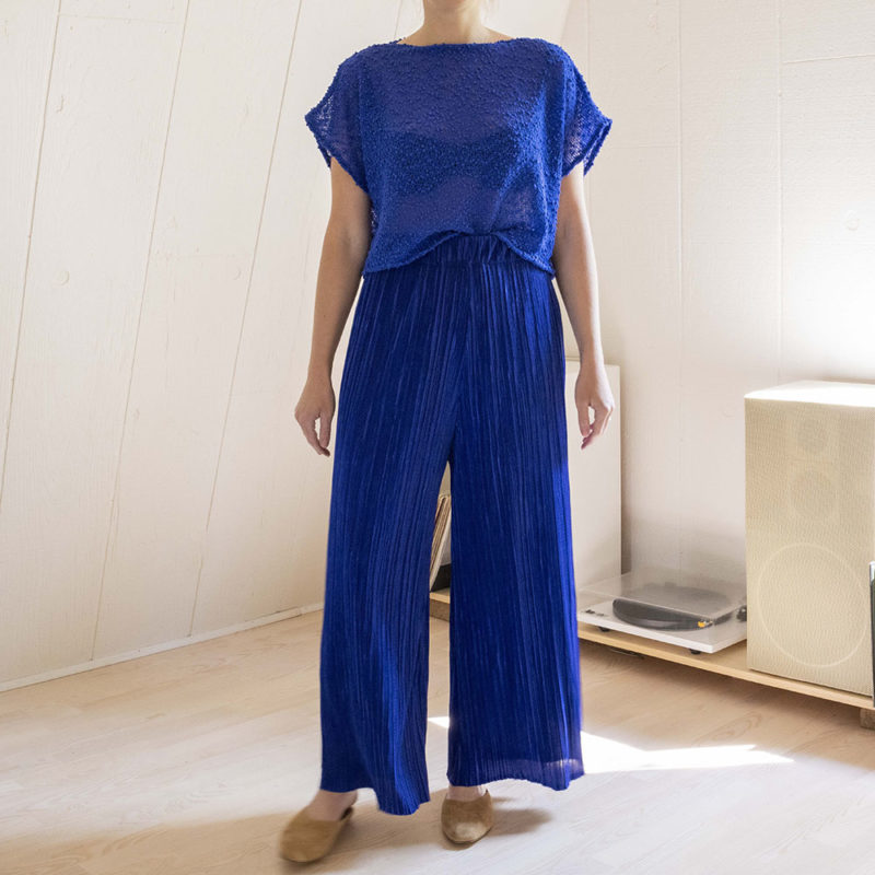 woman in royal blue pleated wide-leg pants and royal blue knit short sleeve top
