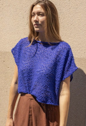 woman in bright cobalt blue slub knit short sleeve boatneck top and maroon skirt