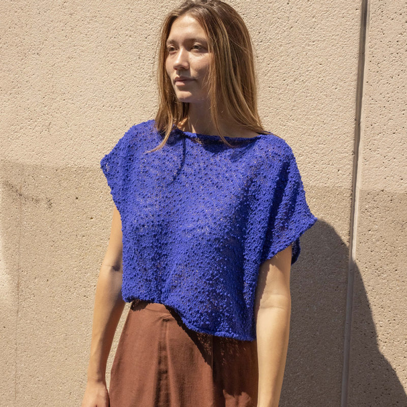 woman in bright cobalt blue slub knit short sleeve boatneck top and maroon skirt