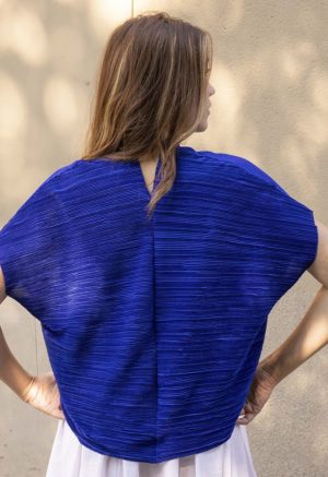 woman in cobalt blue v-neck top over white cotton skirt