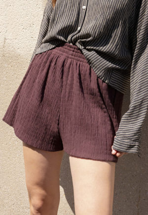 woman in dark chocolate brown shorts and black and white button-up shirt