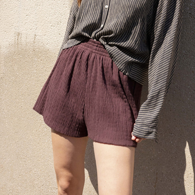 woman in dark chocolate brown shorts and black and white button-up shirt