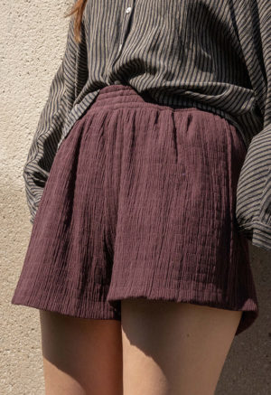 woman in dark chocolate brown shorts and black and white button-up shirt